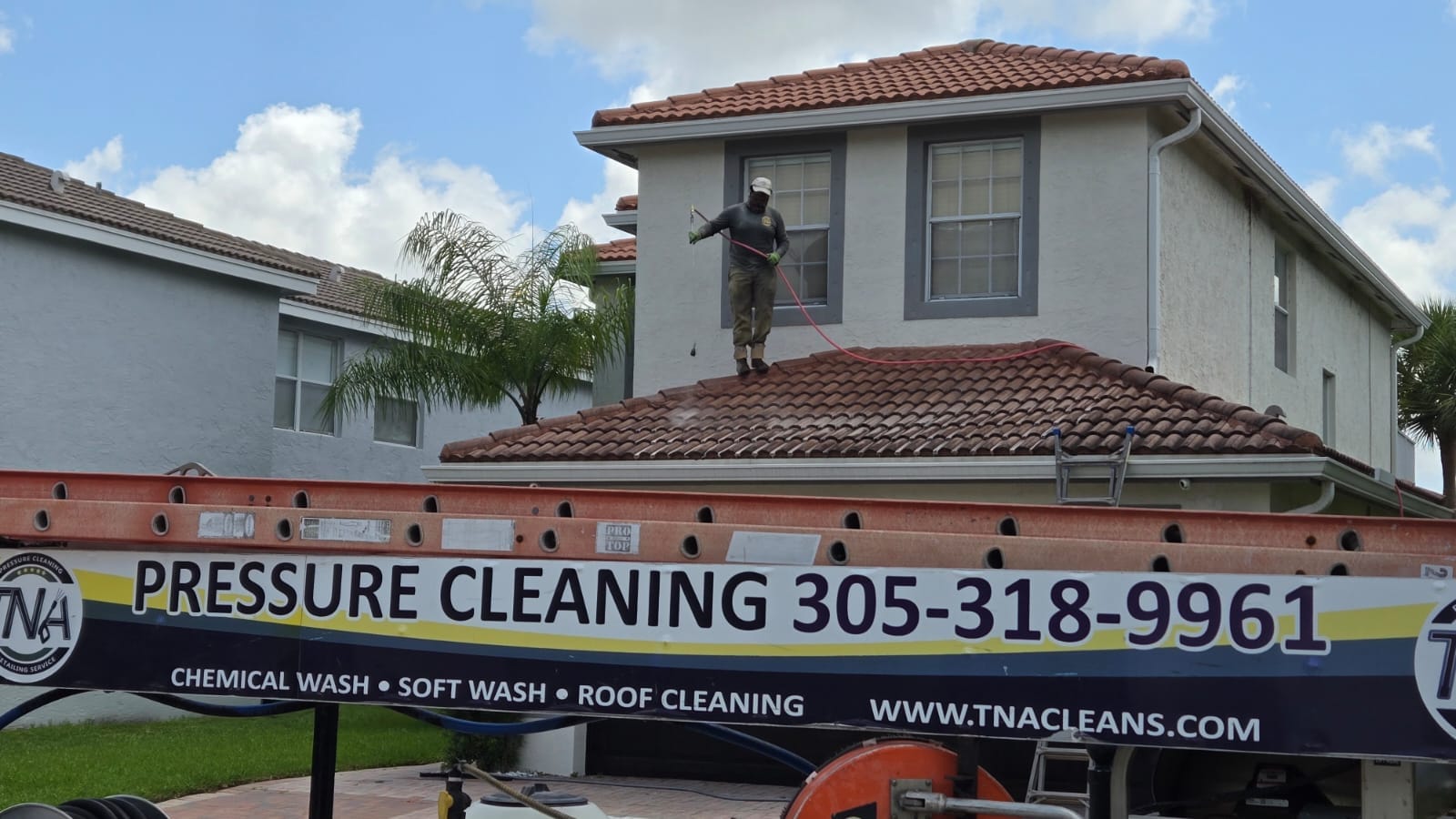 TNA Cleans technician soft washing a tile roof in South Florida